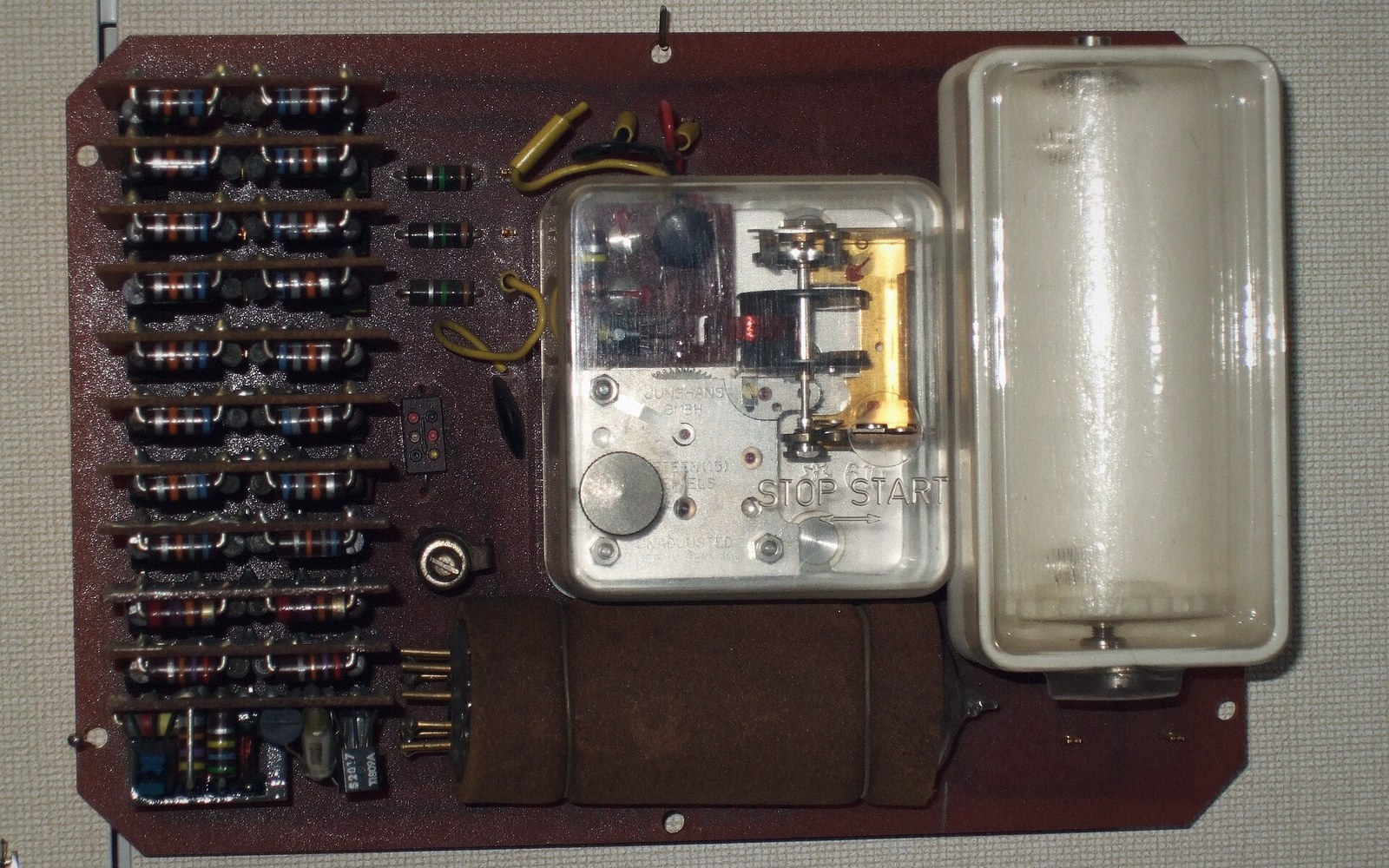 Circuit board with rows of resistors, a stop-start relay module, and a fluorescent tube