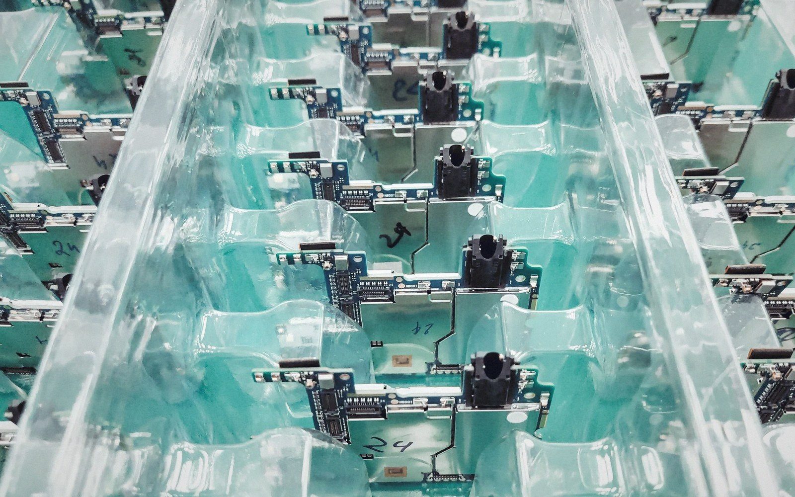 Rows of circuit boards with sensors held in translucent green plastic mounting trays